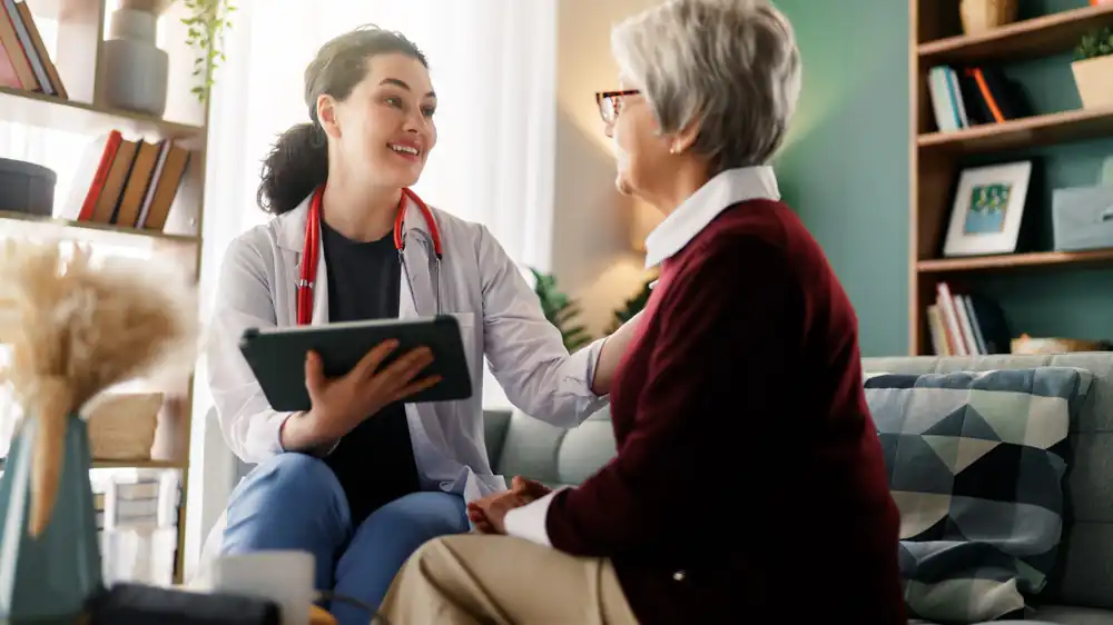 Licensed clinician speaking with an older woman at home