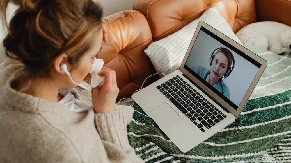 Woman on a telehealth video call from her sofa
