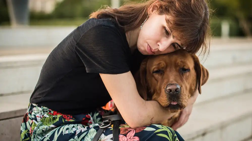 Woman hugging her dog for comfort